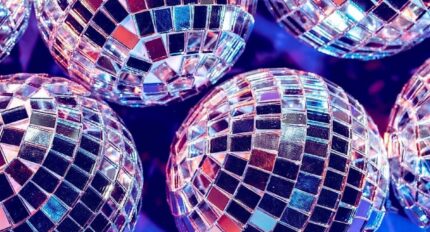 Sparkling disco balls reflecting vibrant lights in a lively hotel party venue, creating a festive atmosphere.