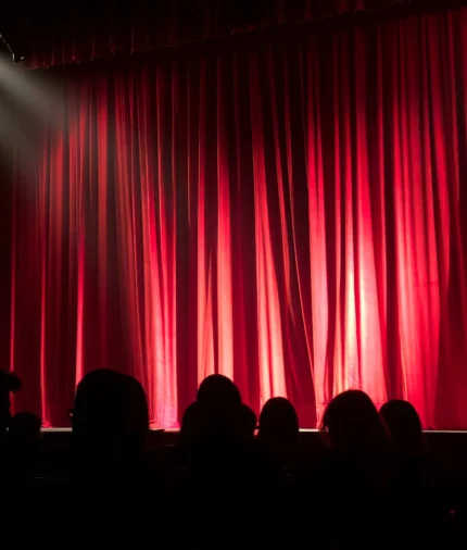 Experience an elegant hotel theatre with plush red curtains, perfect for live performances and events.